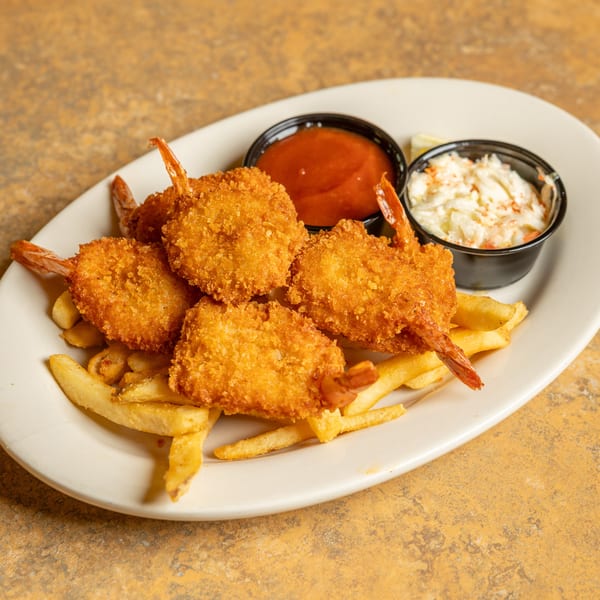 A plate of golden-brown fried shrimp and french fries, with sides of coleslaw and cocktail sauce.