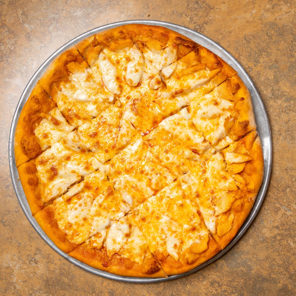 A freshly baked cheese pizza, cut into squares, on a metal pan.