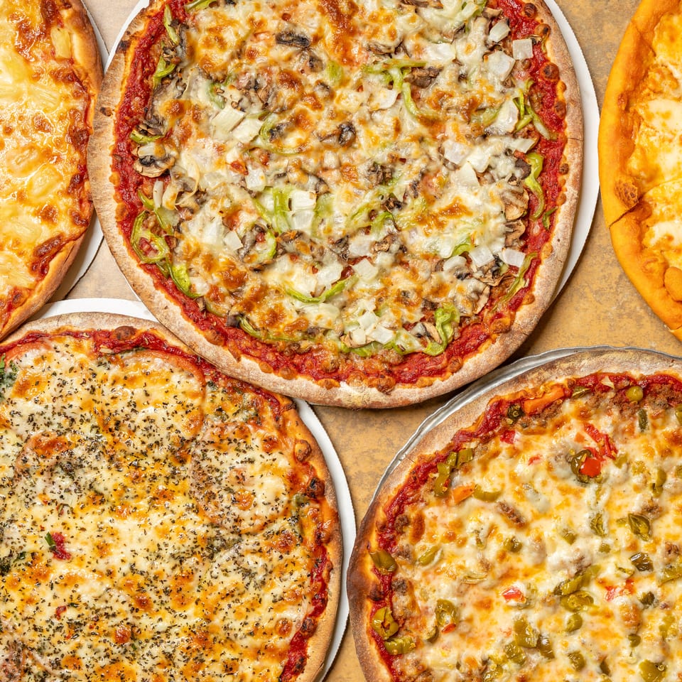 Five delicious pizzas with various toppings, including pineapple, vegetables, and cheese.